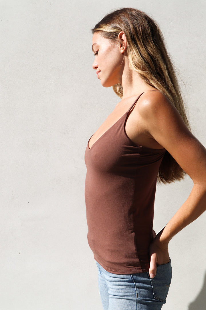 Product shot of NŪD Apparel Nesha Double Layer Tank in dark nude paired with light wash denim, side view.