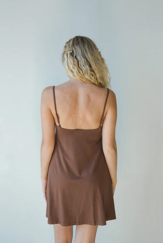 Product shot of NŪD Apparel Betty Swing Dress in dark nude, back view.