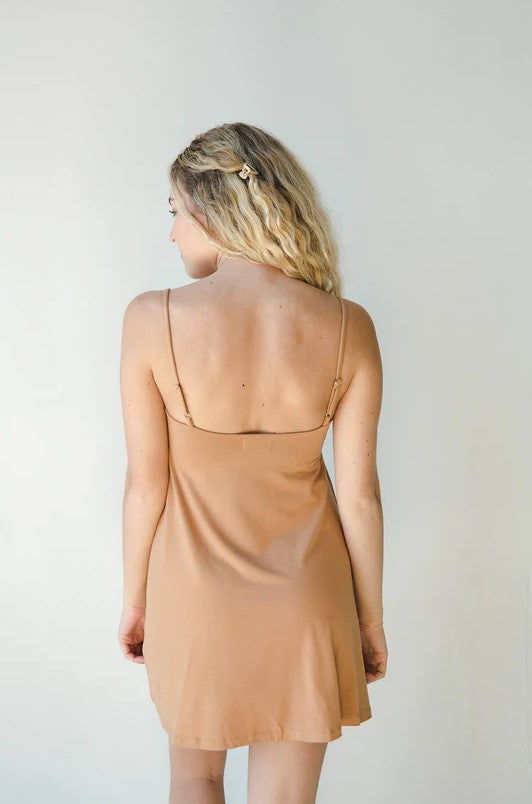 Product shot of NŪD Apparel Betty Swing Dress in medium nude, back view.