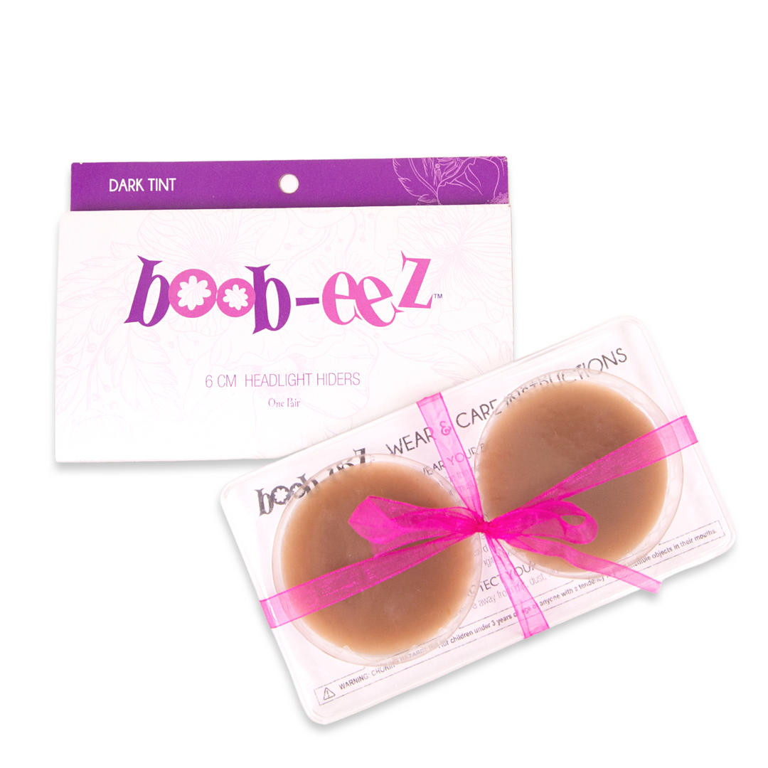 Product shot of Boob-eez 6cm dark tint nipple covers in craft packaging.