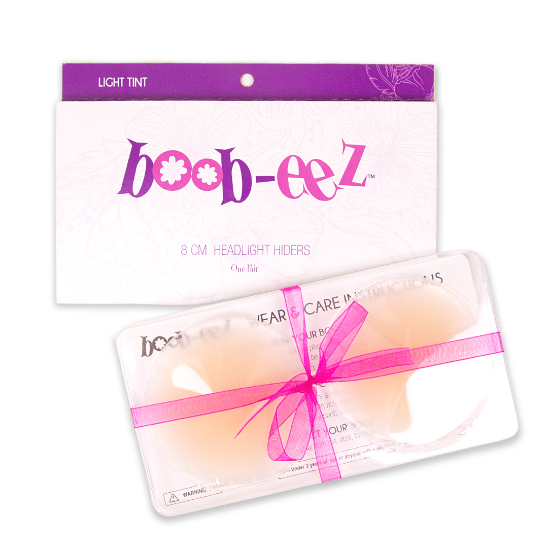 Product shot of Boob-eez 8cm light tint nipple covers in craft packaging.