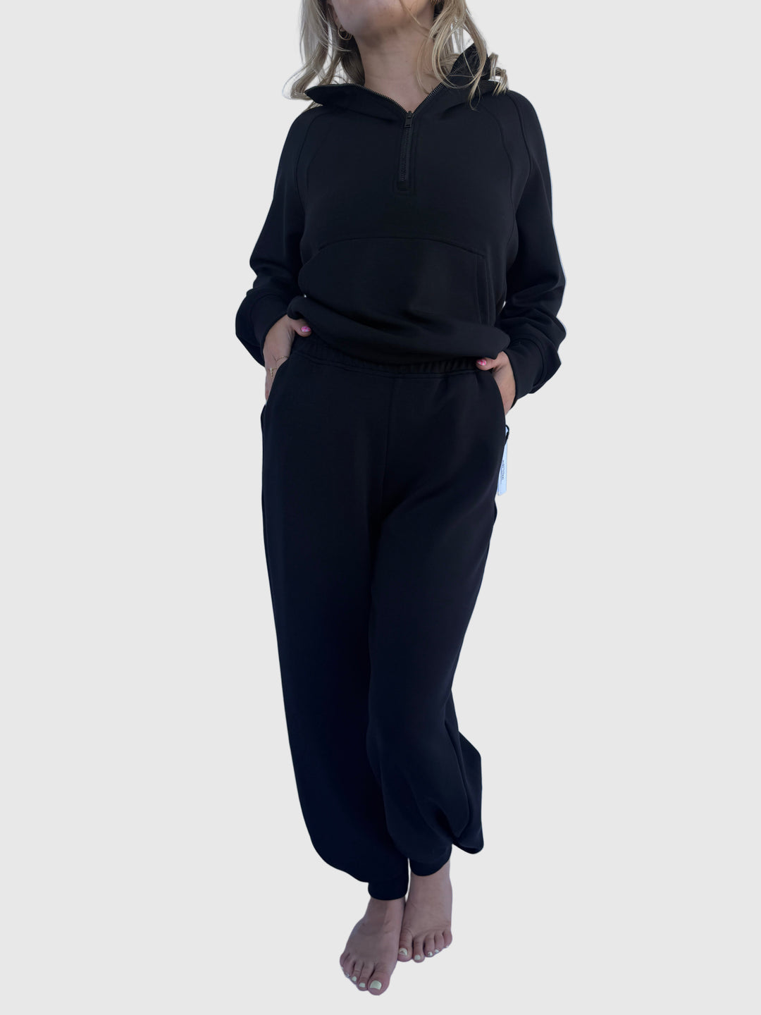 Person wearing a black outfit on a light background