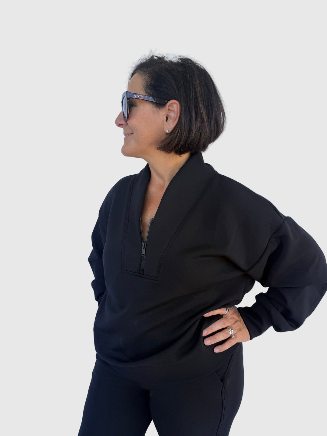 Person wearing a black outfit against a light background