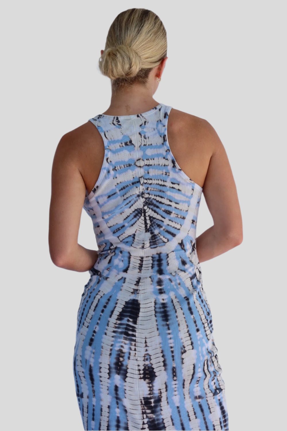 Person wearing a blue and white tie-dye dress against a light blue background