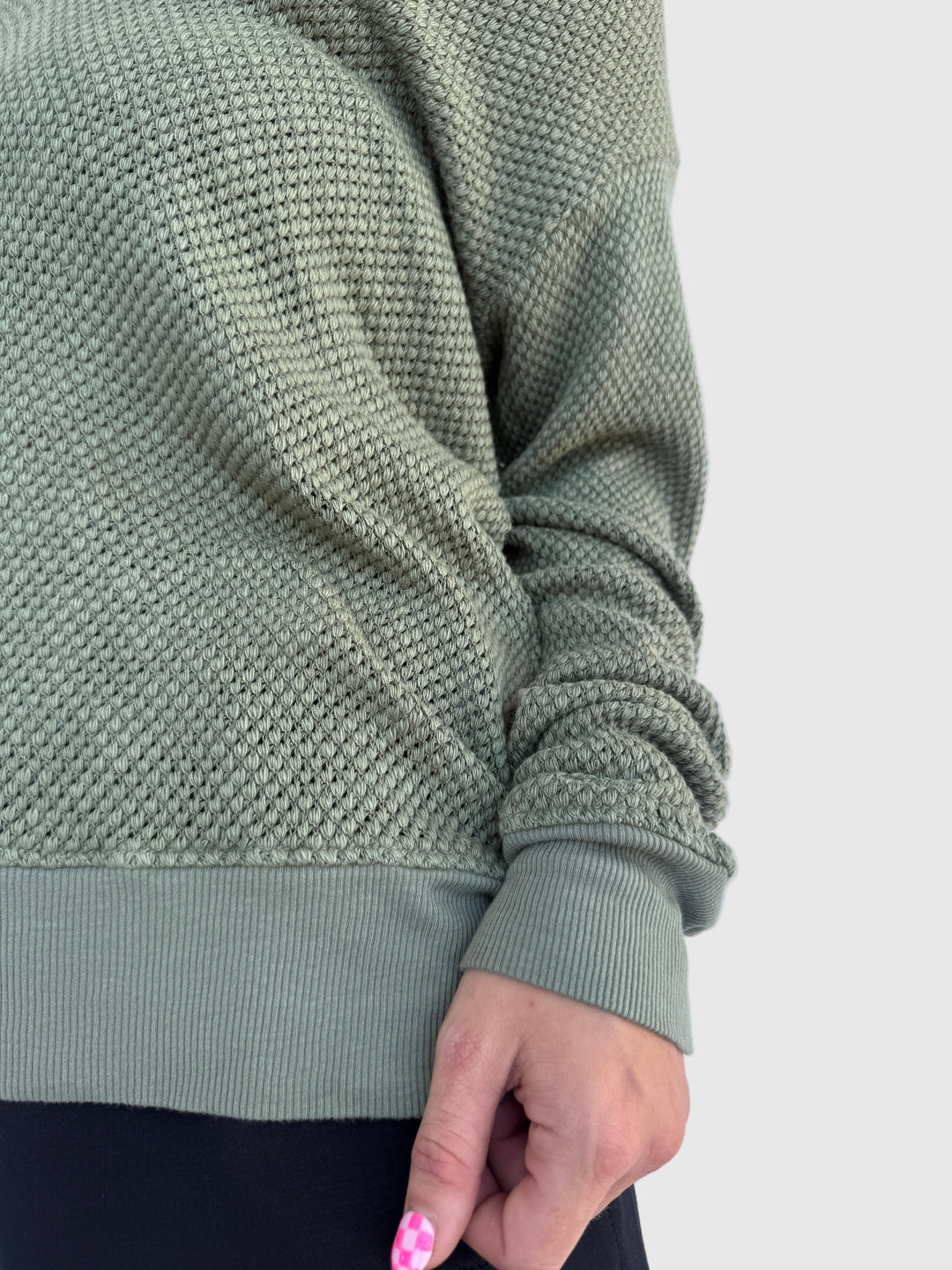 Close-up of a green knitted Gabrielle V Neck Top