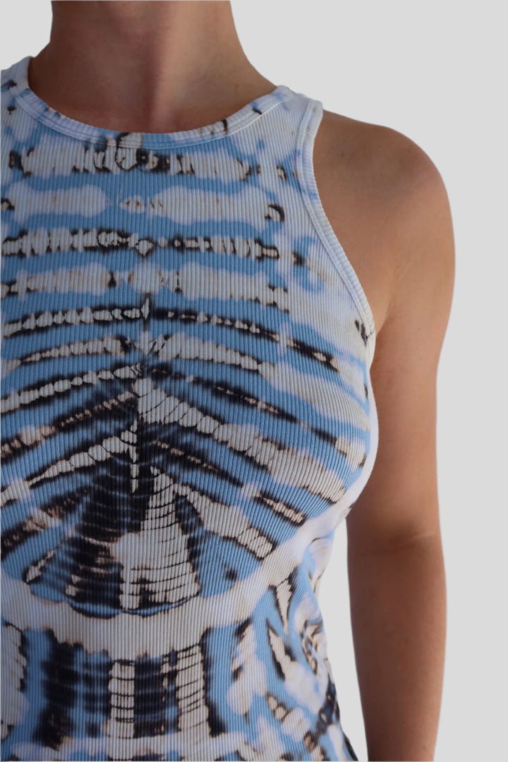 Close-up of a sleeveless top with a blue and white pattern on a plain background