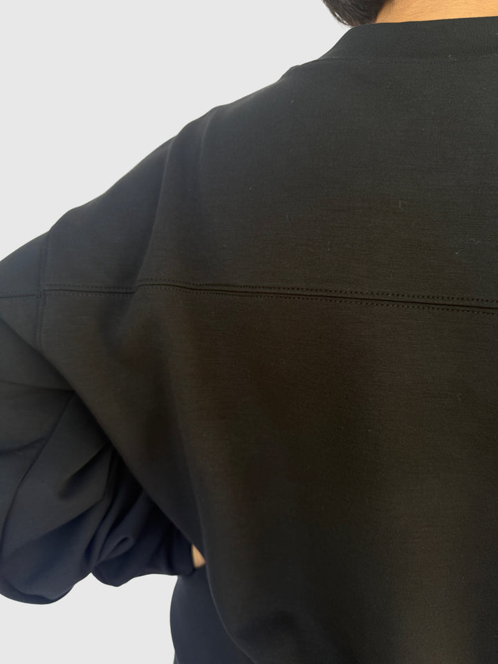 Close-up of a person wearing a dark jacket on a light background