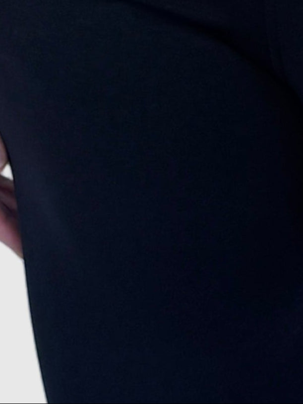 Person wearing a black outfit against a light background