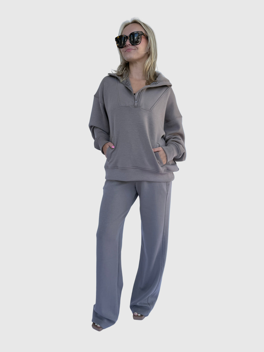 Person wearing a gray tracksuit on a light background