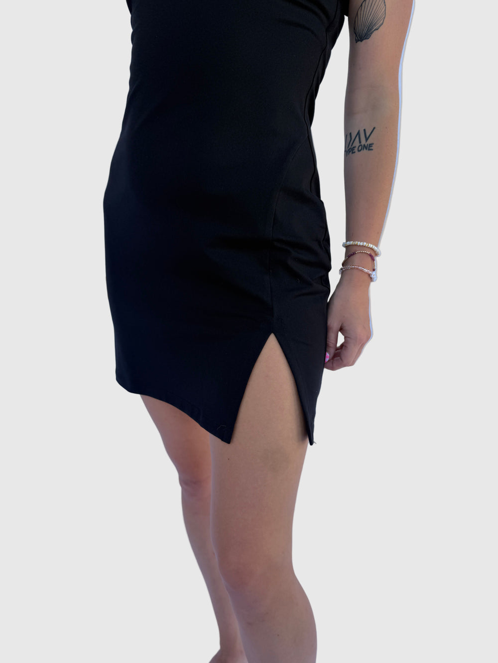 Person wearing a black dress on a light grey background