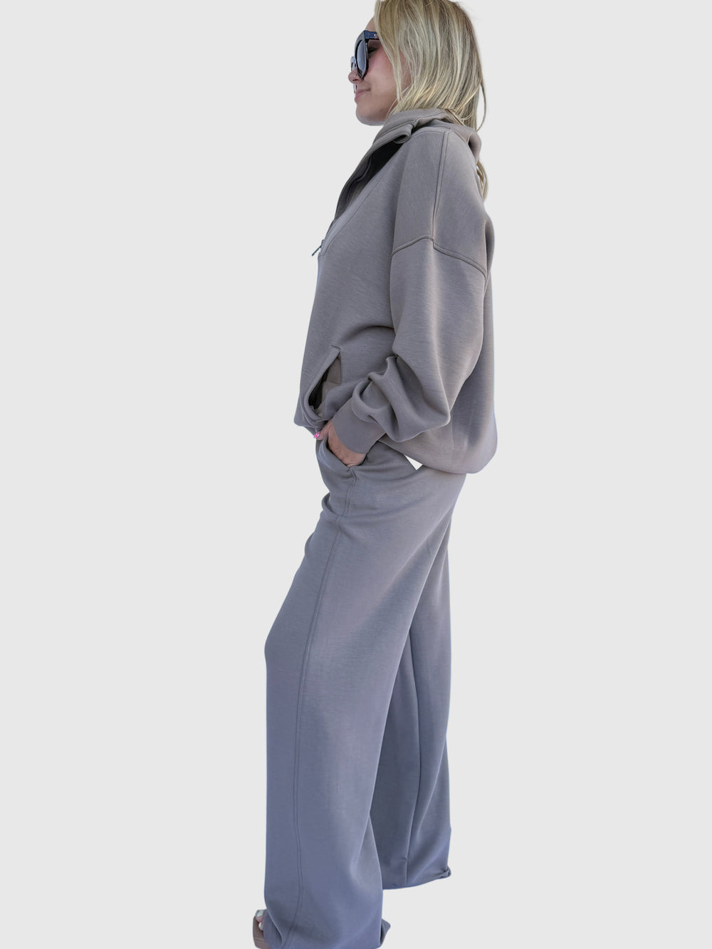 Person wearing a gray sweatshirt against a light background
