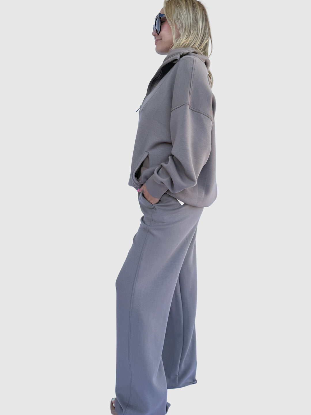 Person wearing a gray sweatshirt against a light background