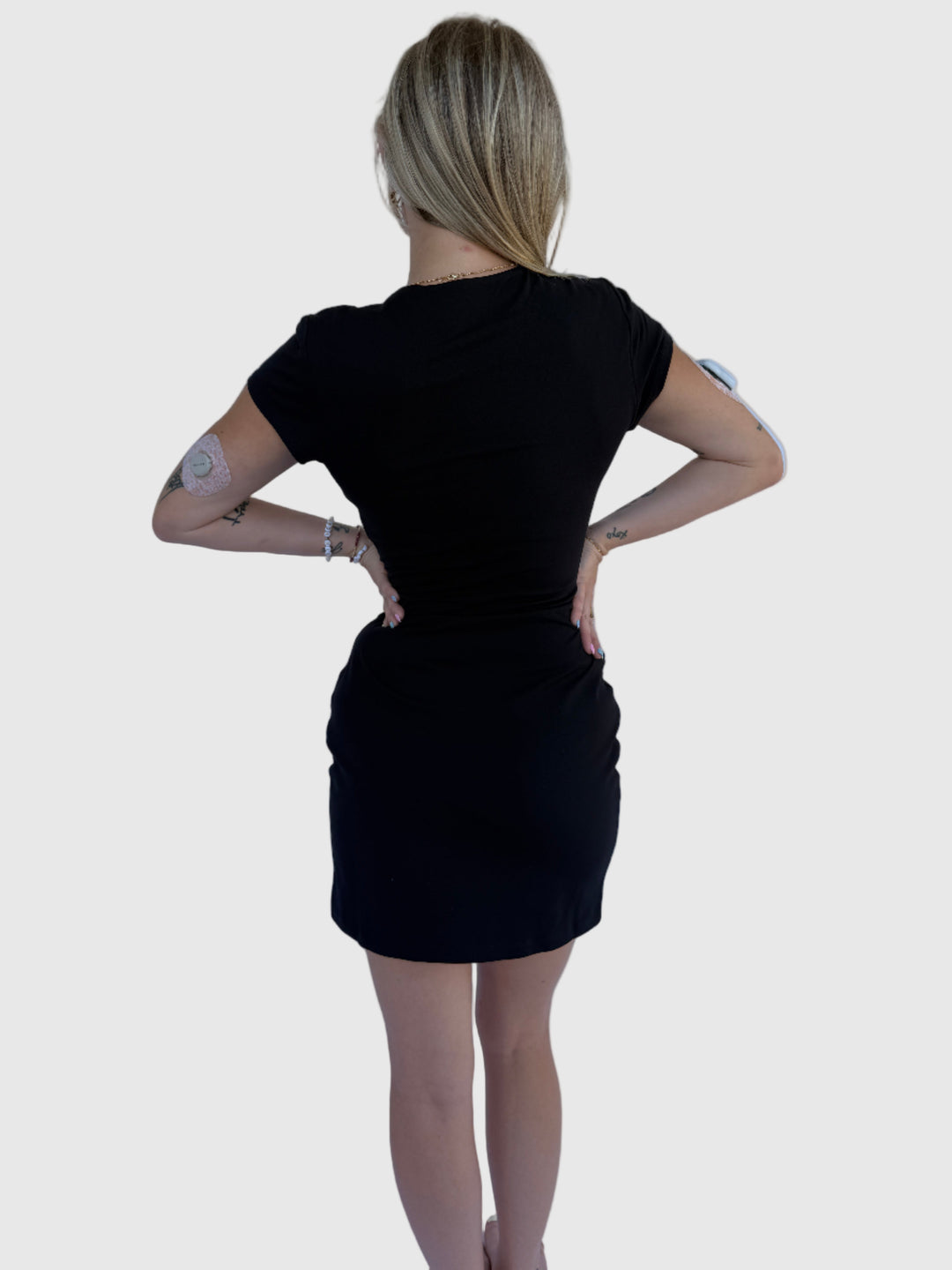 Person wearing a black dress on a light background