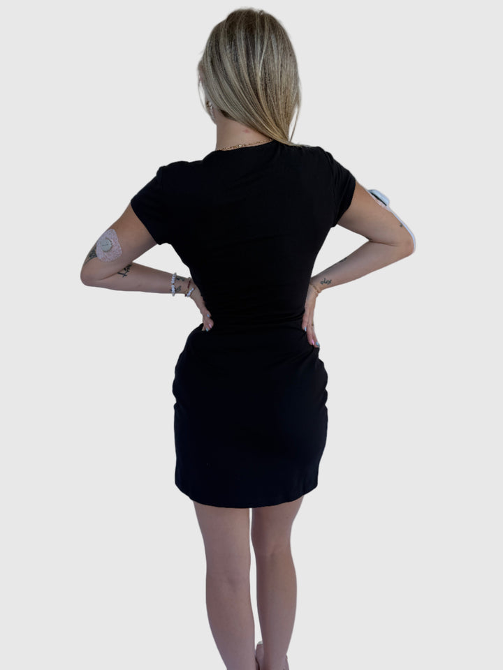 Person wearing a black dress on a light background