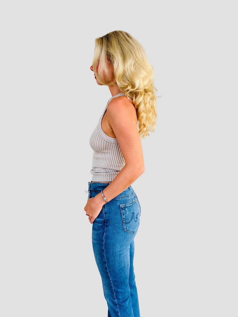 Side view of woman wearing a tan ribbed tank with Jacksonville Jaguar logo patch