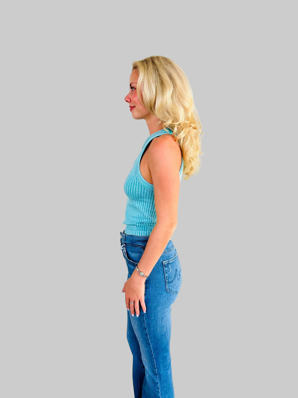 Side view of woman wearing teal ribbed tank top with Jaguar game day patch