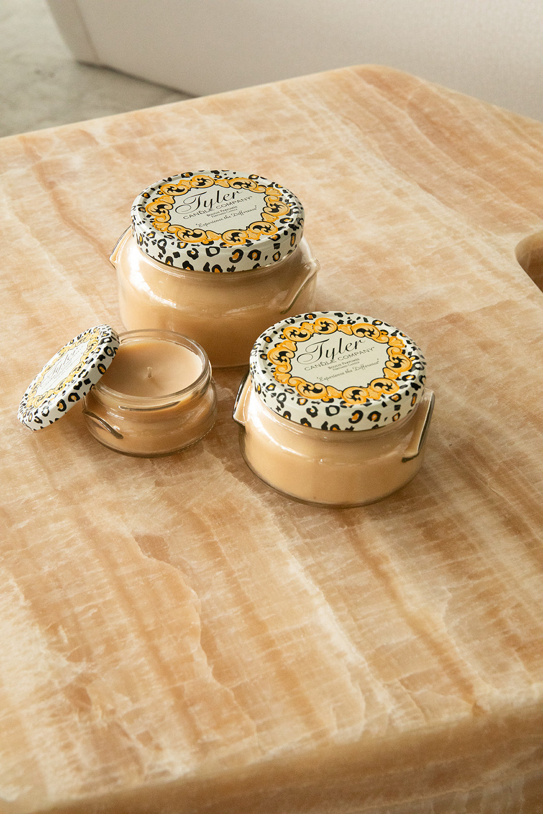 Product shot of Tyler Candle Company candles in 22oz, 11oz, and 3.4oz in scent icon.