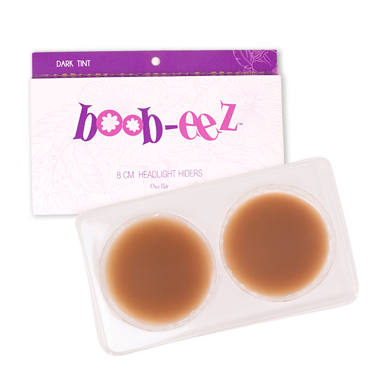 Product shot of Boob-eez 8cm dark tint nipple covers in craft packaging. 